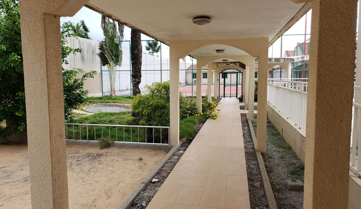 villa avec piscine jet d'eau et terrain de piscine semé long couloir