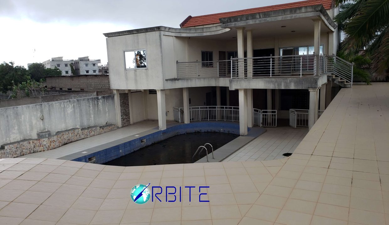 villa piscine jet d'eau terrain de ténis semé vue sur piscine et terrasse grand hall